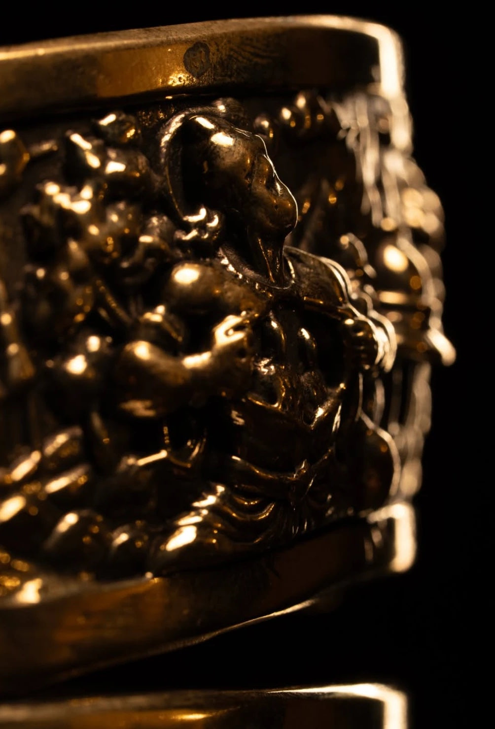 Close-up of the embossed figures on the brass frieze