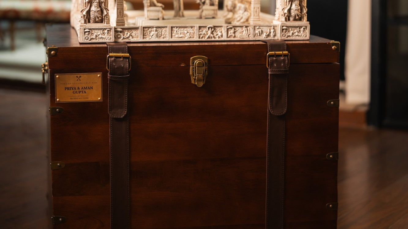 The wooden sandook with its brass name-plate, leather straps and clasp, the artefact resting on top